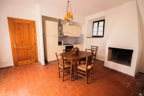 Wohnbereich mit Küche, Esstisch und Kamin