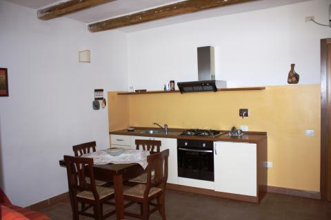 Wohnbereich mit Couch, Esstisch und Küche