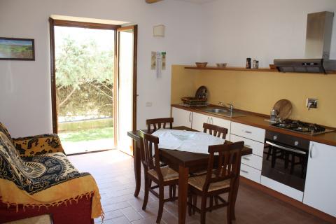 Wohnzimmer mit Küche, Esstisch und Stühlen. Wohnung Ginestra (Ginster) im Agriturismo Francesca in der Toskana.